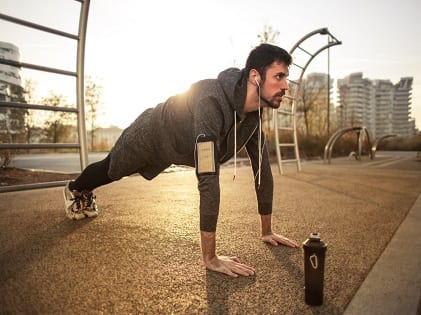 man-in-gray-jacket-doing-push-ups-during-sunrise