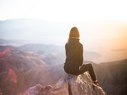 woman sitting on top of the mountain